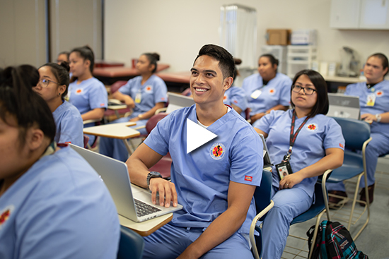 A video showing a smiling HMC student and his peers in their scrub uniforms. 