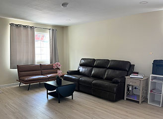 Comfortable living room at HMC Care Home in Honolulu, featuring modern seating, natural light, and a welcoming space for residents and visiting family.