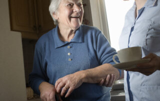 HMC Home Care caregiver offering companionship and support to a smiling senior woman, highlighting comfort, trust, and daily in-home care services