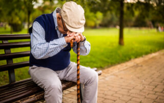 senior man sitting alone on park bench showing quiet signs a loved one may need more support and compassionate home care assistance